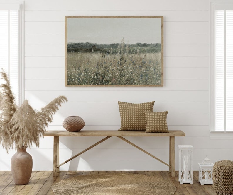 Puede incluir: Un banco de madera con dos cojines de color beige se encuentra frente a una pared blanca con una fotograf&iacute;a de paisaje enmarcada. Un jarr&oacute;n con hierba de la pampa seca se encuentra en el suelo a la izquierda del banco.