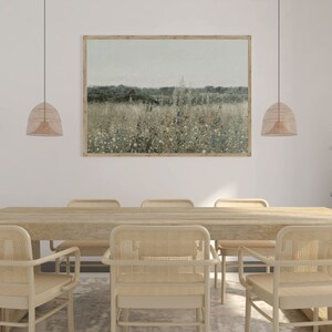 Puede incluir: Una mesa de comedor de madera con seis sillas de mimbre tejido. La mesa est&aacute; adornada con una gran impresi&oacute;n enmarcada de un campo de flores silvestres. Dos l&aacute;mparas colgantes de mimbre cuelgan sobre la mesa.