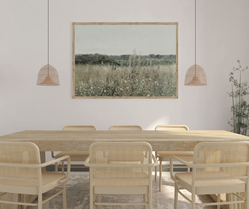 Puede incluir: Una mesa de comedor de madera con seis sillas de mimbre tejido. La mesa est&aacute; adornada con una gran impresi&oacute;n enmarcada de un campo de flores silvestres. Dos l&aacute;mparas colgantes de mimbre cuelgan sobre la mesa.