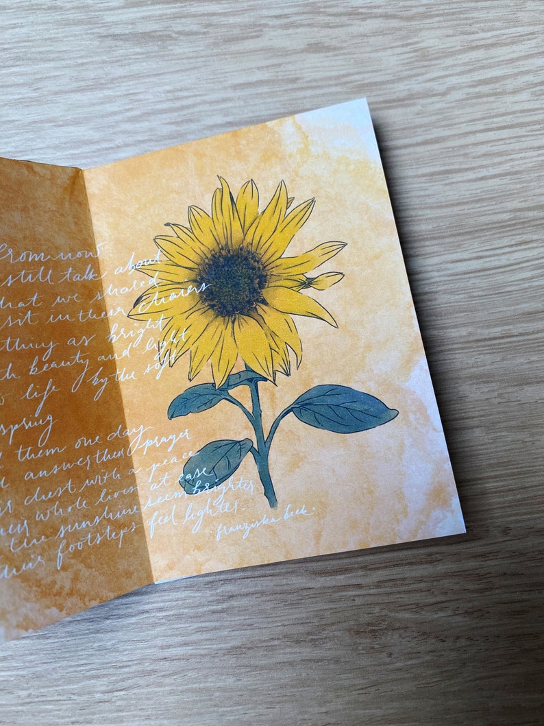 May include: A watercolour painting of a sunflower with a yellow centre and green leaves. The background is a light yellow watercolour wash. The text "Prom now still talk about what we shared dreams sit in their chairs as bright and beauty care life by the spring spring them one day prayer answers then a peace chest with at ease the whole love seem brighter the sunshine feel lighter. franziska beck." is written in white ink on the page.