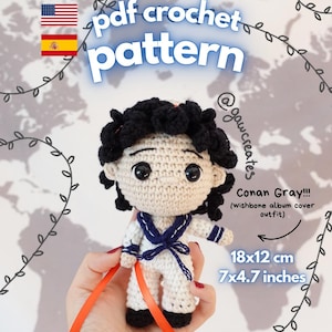 May include: A crochet doll featuring black curly hair, large black eyes, and a white sailor-style outfit with a dark blue collar and tie. The doll measures 7x4.7 inches. Text on the image includes pdf crochet pattern, Conan Gray!!!, and instant download.