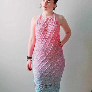 May include: A floor-length crochet dress featuring a halter neckline and a diamond-shaped openwork pattern. The garment displays a gradient color transition, shifting from a vibrant pink at the top to a soft blue and light green at the hem.