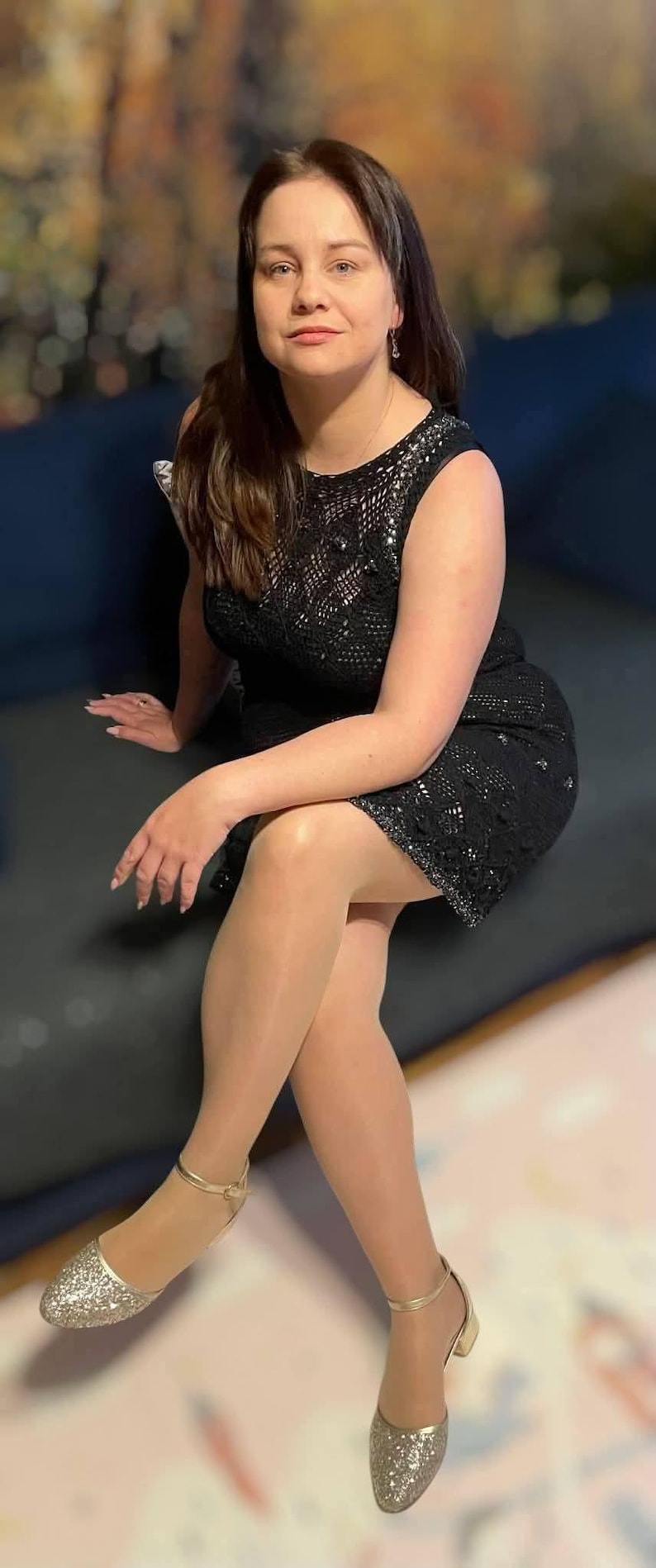 May include: A sleeveless black dress featuring an intricate crochet pattern with subtle shimmering accents, paired with gold-toned glittery low-heeled shoes that have a delicate ankle strap, creating a cohesive and textured ensemble for formal occasions.