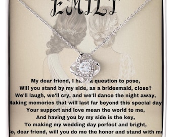 May include: A silver-toned necklace with a sparkling pendant, presented in a gift box. The box features the name "EMILY" at the top and a poem about friendship and weddings. The pendant is a knot design with a central clear stone.