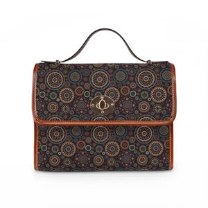 May include: A rectangular handbag with a brown handle and trim. The bag features a dark background with a repeating pattern of colorful circular designs in shades of orange, blue, and brown. A gold-colored clasp secures the flap.