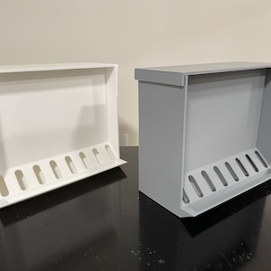 May include: Two wall-mounted storage organisers, one white and one grey, with multiple slots for holding items.