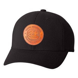 May include: Black baseball cap with a brown leather patch featuring the text "Tafuna High School" and a logo with the text "Fina'nau I mea lelei".