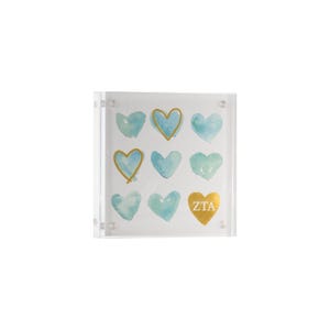 May include: Clear acrylic block featuring nine watercolor hearts in shades of blue and gold. One heart is gold with the letters "ZTA". The hearts are arranged in a grid pattern, creating a decorative piece.