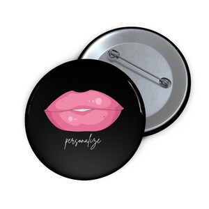 May include: A round pinback button featuring a black background with a graphic illustration of bright pink lips in the center. Below the lips, the word personalize is written in a white cursive script. The back shows a silver metal pin mechanism.