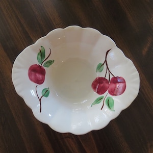 May include: White ceramic bowl with a scalloped edge and a hand-painted design of red apples and green leaves.