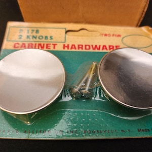 May include: Two silver cabinet knobs with screws on a green and white packaging card. The card reads "# 178 2 Knobs Cabinet Hardware Two For".