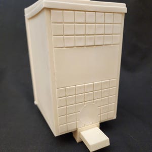 May include: A white plastic trash can with a square shape and a small opening on the front. The can has a textured surface that resembles small squares.