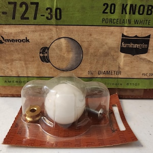 May include: A package of 20 porcelain white cabinet knobs. Each knob is a round, white sphere with a 1.5-inch diameter. The packaging includes the Amerock logo and the text "furnituretrim".