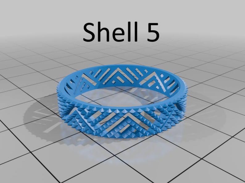 May include: A light blue ring with a geometric design. The ring has a repeating chevron pattern and small, pointed details around the edges. The text "Shell 5" is above the ring.
