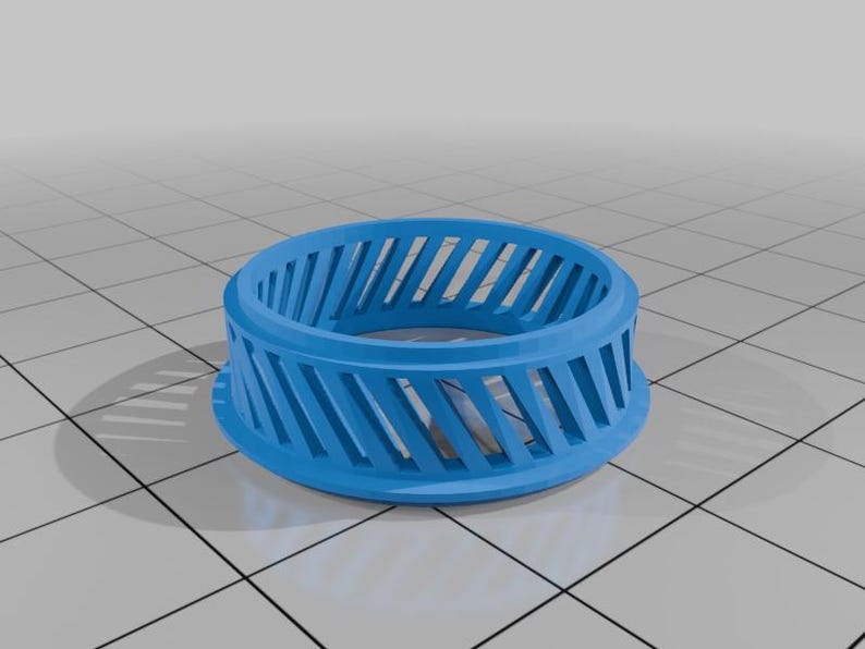 May include: A vibrant blue, ring-shaped object featuring a series of angled slots around its perimeter. The item has a flat base and a curved top, giving it a circular form. The design suggests a decorative or functional item, possibly a component.