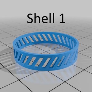 May include: A vibrant blue ring with diagonal cut-out sections, marked "Shell 1". The ring has a series of evenly spaced, angled slots around its circumference. The design is simple and modern, with a clean aesthetic.