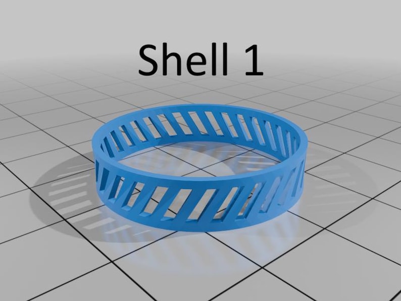 May include: A vibrant blue ring with diagonal cut-out sections, marked "Shell 1". The ring has a series of evenly spaced, angled slots around its circumference. The design is simple and modern, with a clean aesthetic.