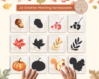 May include: A set of 12 matching cards with watercolor illustrations of autumn elements, including an acorn, berries, leaves, a pumpkin, and a squirrel. Each image has a corresponding silhouette. The text "24 Schatten Matching Kartenpaaren" is at the top.