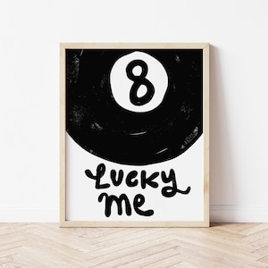 May include: Black and white illustration of a pool ball with the number 8 on it. The text "Lucky Me" is written below the ball.