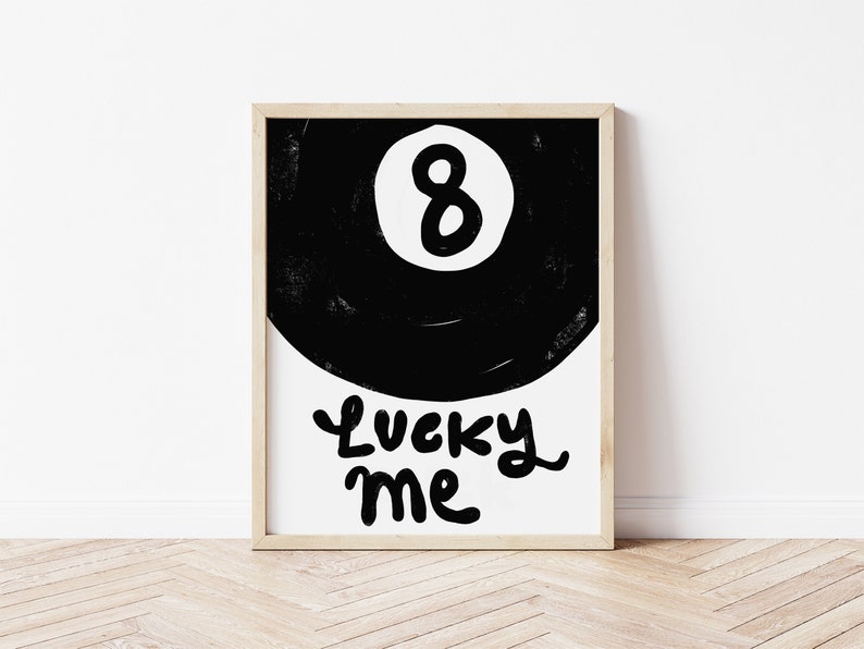May include: Black and white illustration of a pool ball with the number 8 on it. The text "Lucky Me" is written below the ball.