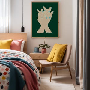 Large dark green poster, there is a picture of hands entwined in the centre of the artwork. It has a modern mid century style. The wall art in hanging ins a colorful bedroom