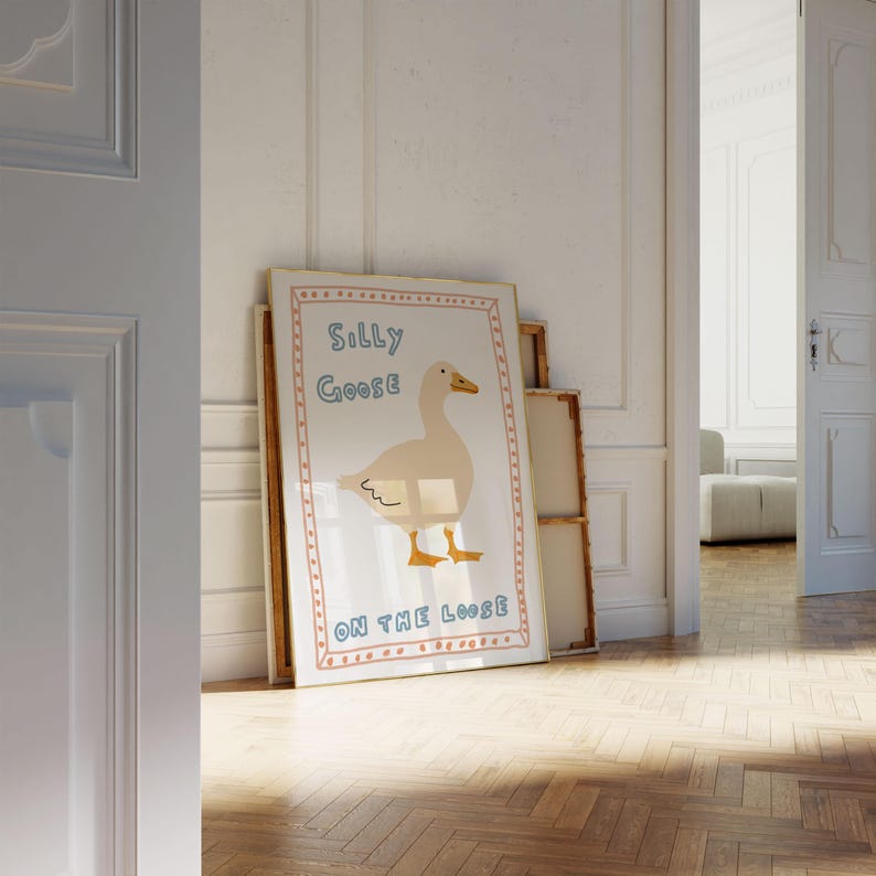 Peut inclure: Une illustration encadr&eacute;e d'une oie blanche avec le texte "Silly Goose On The Loose" dans un style dessin&eacute; &agrave; la main color&eacute;.