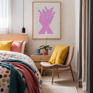 May include: A framed print of a minimalist line drawing of two hands clasped together. The hands are pink with blue nail polish. The print is hanging on a white wall in a bedroom.