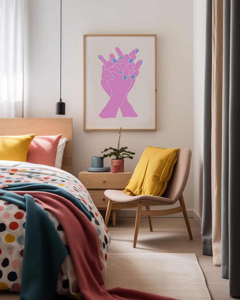 May include: A framed print of a minimalist line drawing of two hands clasped together. The hands are pink with blue nail polish. The print is hanging on a white wall in a bedroom.
