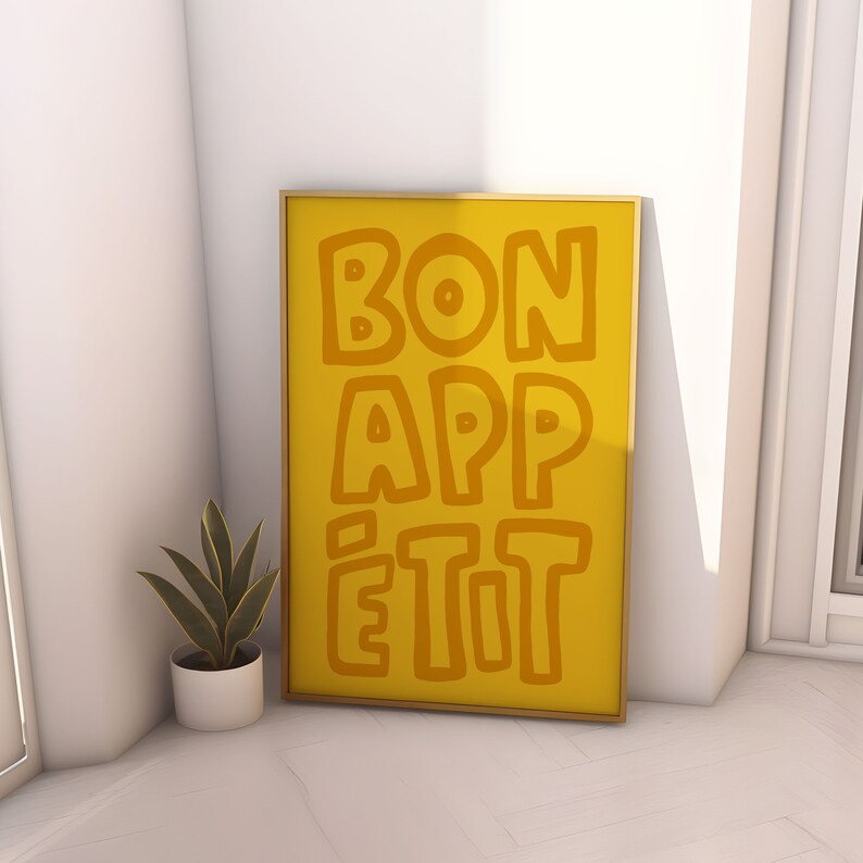 May include: A yellow framed poster with the text "BON APP&Eacute;TIT" in a playful, hand-drawn font.
