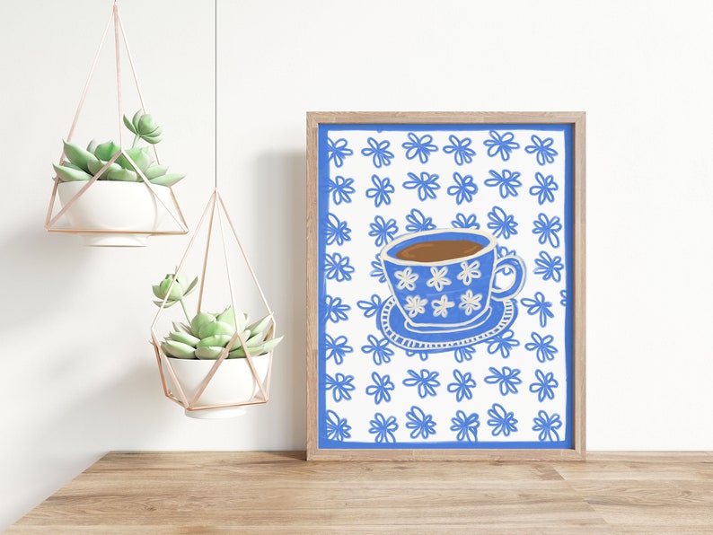May include: A framed print of a blue and white teacup with a floral pattern on a white background with a blue floral pattern.