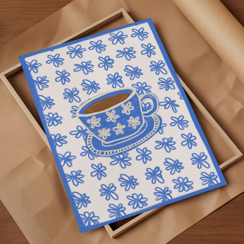 May include: A white teacup with a blue floral pattern and brown liquid inside, sitting on a white saucer with a blue floral pattern. The teacup and saucer are on a white background with a blue floral pattern.
