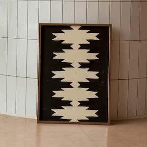May include: A framed black and white geometric print with a pattern of white zigzags on a black background.