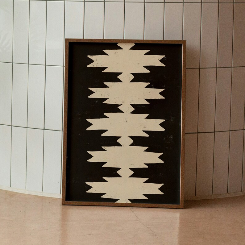 May include: A framed black and white geometric print with a pattern of white zigzags on a black background.