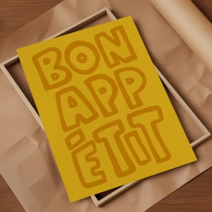 May include: A yellow poster with the words "BON APPETIT" written in a bold, stylized font.