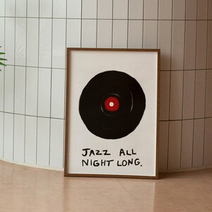 May include: A framed print with a black and white illustration of a vinyl record with a red center. The text "JAZZ ALL NIGHT LONG." is written in black below the record.