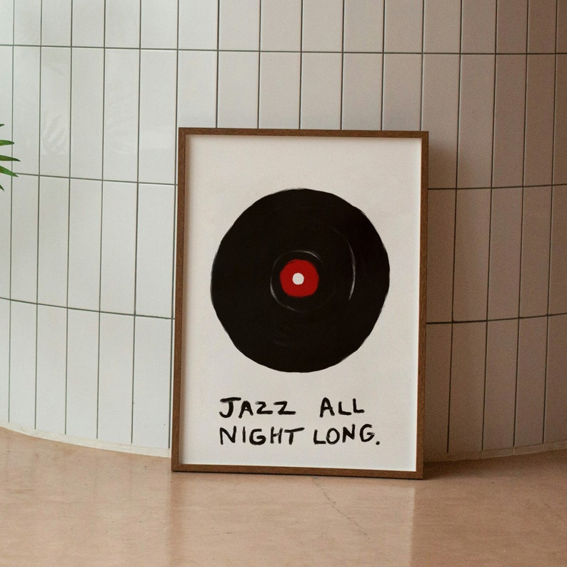 May include: A framed print with a black and white illustration of a vinyl record with a red center. The text "JAZZ ALL NIGHT LONG." is written in black below the record.