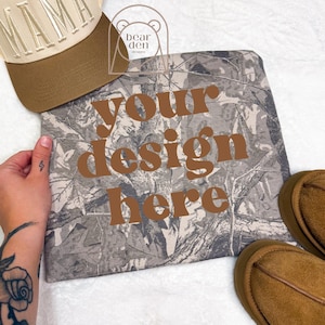 May include: A camouflage-patterned item with the text "your design here" in brown. A brown and beige baseball cap with "MIAMI" embroidered on it is visible. Brown shoes are also in the image.