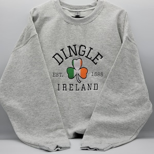 May include: A gray sweatshirt with a black print that says "Dingle, Est. 1585, Ireland" with a green shamrock and the Irish flag colors in the center.
