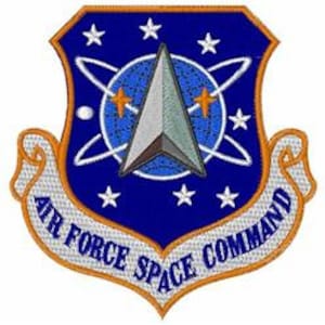 May include: A blue and white patch with a silver star and the text "Air Force Space Command" in a white banner.