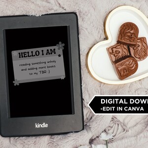 May include: A black and white digital reader with the text "HELLO I AM reading something unholy and adding more books to my TBR :)" on the screen. The reader is on a light brown fuzzy surface with a heart-shaped dish with three chocolate candies on it. The text "DIGITAL DOWNLOAD -EDIT IN CANVA" is at the bottom of the image.