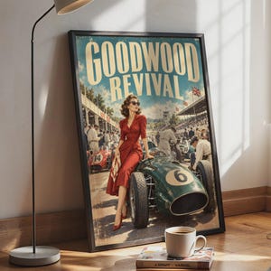 May include: A framed poster titled GOODWOOD REVIVAL featuring a vintage racing scene. A person in a red dress and sunglasses leans against a green race car with the number 6. The background shows a racetrack, spectators, and other cars.