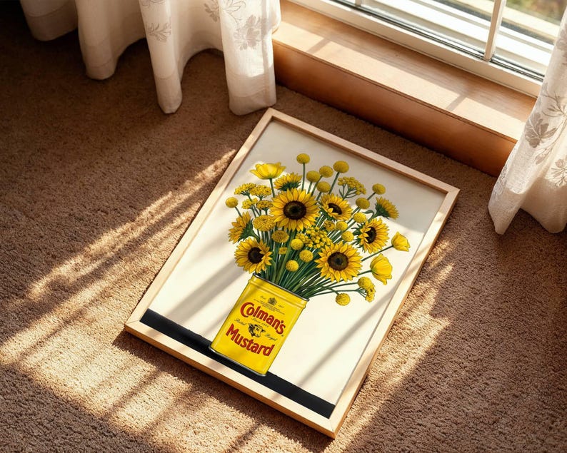 May include: A framed print featuring a bouquet of bright yellow sunflowers and billy buttons arranged in a yellow Colman's Mustard tin. The artwork displays the text Colman's Mustard on the front of the tin, set against a light cream background.