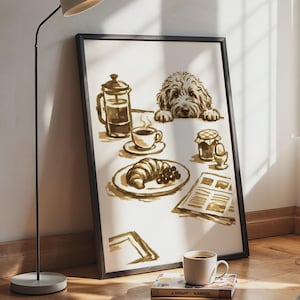 May include: A framed wall art print featuring a sepia-toned illustration of a fluffy dog looking over a table set with a French press, a cup of coffee, a croissant, a jar of jam, a soft-boiled egg in a cup, and a newspaper on a white background.