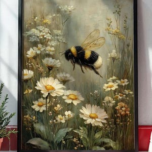 May include: A framed painting shows a bumblebee flying amongst white daisies and wildflowers. The bee has black and yellow stripes. The artwork has a soft, painterly style with a muted colour palette, creating a serene, natural scene.