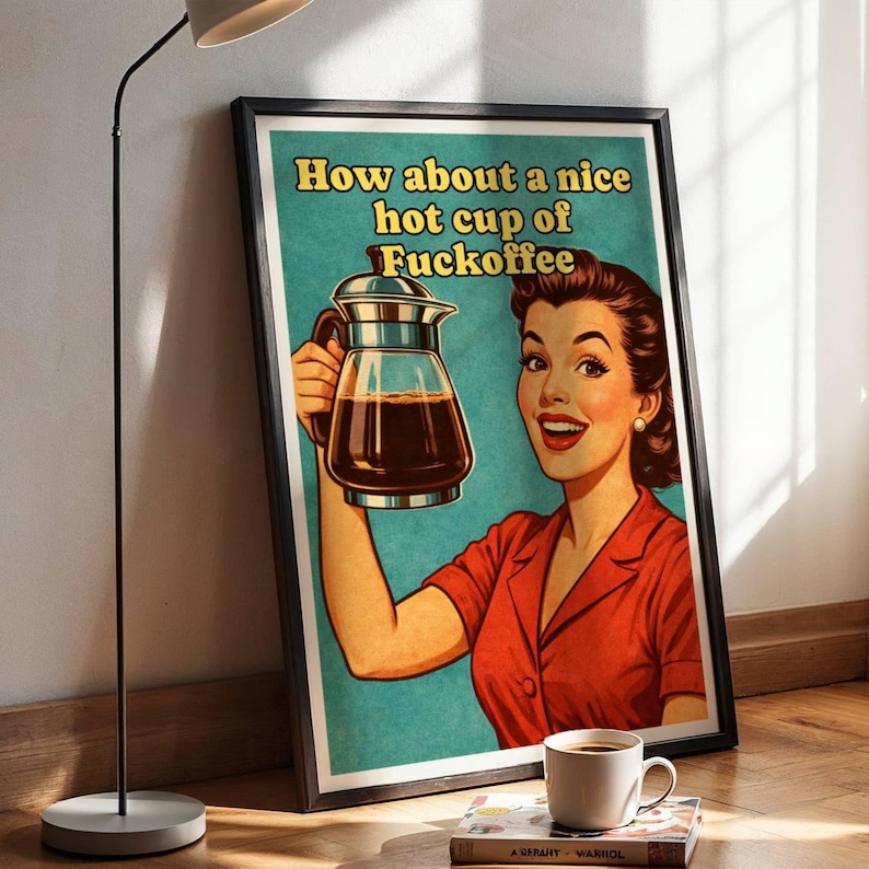 Pu&ograve; includere: Un poster incorniciato con un'illustrazione in stile retr&ograve; di una persona sorridente con una camicia rossa che tiene in mano una caraffa da caff&egrave; in vetro. Il testo recita "How about a nice hot cup of Fuckoffee" in lettere gialle su sfondo verde acqua.