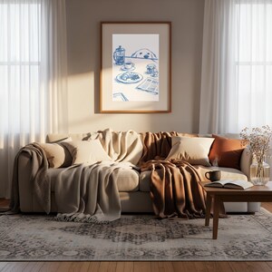 May include: A framed wall art print featuring a blue ink illustration of a breakfast table setting with a French press, a cup of coffee, a croissant, a jar, an egg, and a newspaper, with a dog peeking over the edge of the table.
