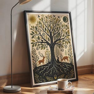 Op de afbeelding: Een ingelijste rechthoekige kunstprint voor aan de muur met een centrale boom met gedetailleerde wortels, omringd door twee herten, een konijn en vogels. De illustratie bevat een zon en een maansikkel in een crème, groen en zwart kleurenpalet.