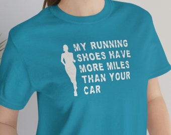 May include: A turquoise blue t-shirt with a white silhouette of a runner and the text "My running shoes have more miles than your car".
