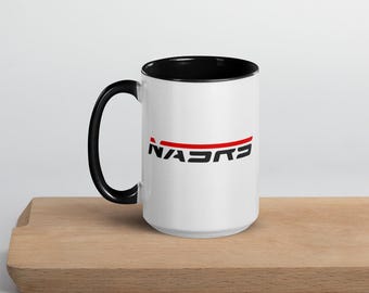May include: White ceramic mug with a black rim and handle. The mug features a red and black NASA logo.