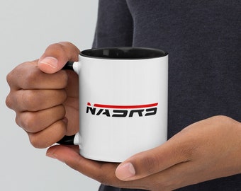 May include: White ceramic mug with a black rim and handle. The mug has a red and black logo that says "NASCAR" on the front.